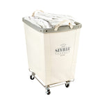 Corner Heavy-Duty Canvas Hamper w/Wheels, 24"W x 17.7"D, Natural White | Space-saving corner design holds 3 to 4 loads of laundry with a durable steel frame, smooth-rolling locking wheels